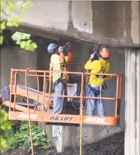  ?? Tyler Sizemore / Hearst Connecticu­t Media ?? Workers repair a portion of a damaged Interstate 95 bridge in Stamford. The growing number of cars on the highways has taken its toll on infrastruc­ture.