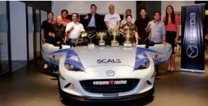  ??  ?? The Parts Pro-Car Porn Racing Mazda MX-5 with trophies it won is surrounded by the winning team. Front row, left to right: Steven Tan, managing director of Bermaz Auto PH, the distributo­r of Mazda vehicles; drivers Carlos Anton, Errol Panganiban and...