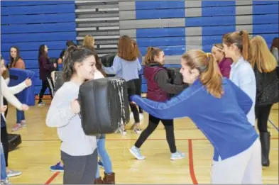  ?? JOSEPH PHELAN — JPHELAN@DIGITALFIR­STMEDIA.COM ?? Sophia Damiano holds the punching bag as Kelsey McFadden provides a punch Thursday afternoon.