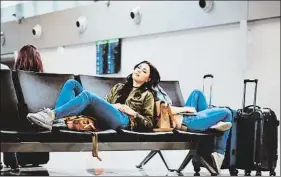  ?? IZUSEK / GETTY IMAGES ?? Dos jóvenes descansan en un aeropuerto esperando la salida de su vuelo