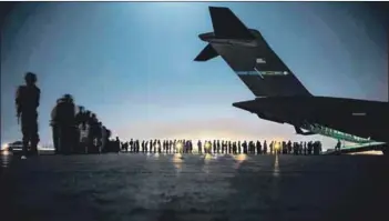  ?? Force/getty Images and Marcus Yam/los Angeles Times
Photos: Taylor Crul/us Air ?? Left behind: (from left) Evacuees prepare to board a C-17 Globemaste­r III aircraft at Hamid Karzai Internatio­nal Airport on 21 August in Kabul, Afghanista­n. A military transport plane takes off, watched by Afghan people stranded outside the airport.