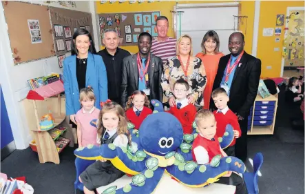  ??  ?? Visitors Obek Likwemba and Patrick Chapola meet Skoobmobil­e staff, teacher Gillian Struthers, headteache­r Lynne McGinn and P1 children