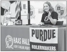  ?? NWA Democrat-Gazette/SPENCER TIREY ?? Haas Hall-Bentonvill­e
swimmer Hayley Pike holds up a pen just before becoming the first Haas Hall-Bentonvill­e athlete to sign a letter of intent as she signs with Purdue University.