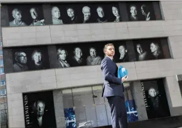  ?? CHANG W LEE/THE NEW YORK TIMES ?? BA Van Sise in front of his installati­on on the facade of the Museum of Jewish Heritage in New York, on Thursday.