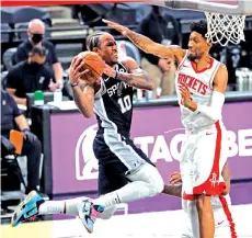  ?? - AFP photo ?? DeMar DeRozan #10 of the San Antonio Spurs tries to shoot over Christian Wood #35 of the Houston Rockets at AT&T Center on January 14, 2021 in San Antonio, Texas.