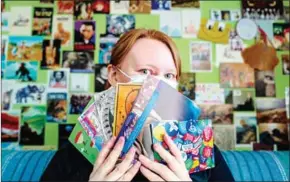  ?? AFP ?? Postcard enthusiast Gesa Funke poses with postcards in her flat in Berlin on March 1 during the Covid-19 pandemic.