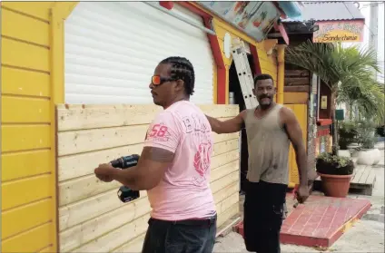  ?? PICTURE: AP ?? Men board up buildings ahead of Hurricane Maria in Sainte-Anne on the French Caribbean island of Guadeloupe on Monday.