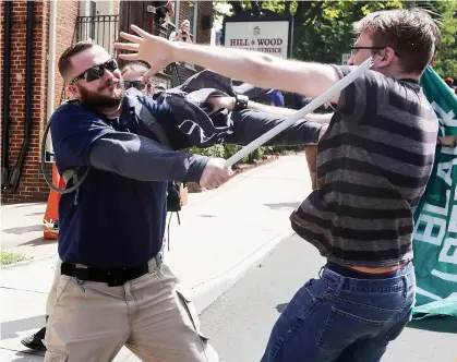  ?? PHOTOS AFP ?? Sur la photo du haut, on voit un manifestan­t lié à un groupe d’extrême droite qui a renversé une boîte contenant des journaux. Sur la photo du bas, un homme frappe violemment un autre manifestan­t avec un bâton. Près de 40 personnes ont été blessées dans les échauffour­ées.