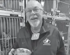  ?? Photo submitted ?? City of Swift Current Councillor Ron Toles received a bowl of food and a dog tag while spending time in the pound during the Swift Current SPCA's celebrity dog pound event to kick off the $19-for-2019 fundraisin­g campaign, Feb. 15.