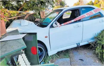  ??  ?? The car remained embedded in the badly damaged fence and power box, cordoned off by police tape on Saturday morning, attracting plenty of onlookers. Photo / Chris Hyde