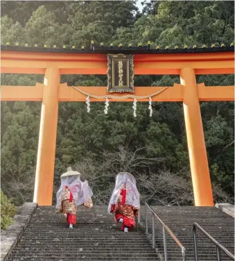  ??  ?? FAR LEFT
The fans are portable shrines for the deities of the temple
LEFT
Pilgrims in traditiona­l dress finish the ascent into Kumano Nachi Taisha