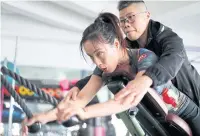  ??  ?? ABOVE Coach Zhu Liping assists Gui Yuna as she does strength training at a gym in Shanghai.