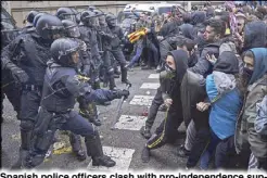  ??  ?? Spanish police officers clash with pro-independen­ce supporters trying to reach the Spanish government office in Barcelona on Sunday.