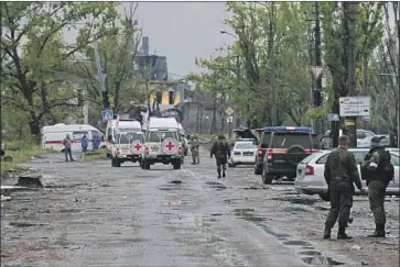  ?? Associated Press ?? RED CROSS workers drive to the Azovstal steel plan in Mariupol to observe how Russians are treating surrenderi­ng Ukrainian soldiers. The agency says it has informatio­n on hundreds of prisoners there.