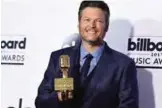  ??  ?? Blake Shelton poses in the press room with the award for Top Country Artist.