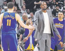  ??  ?? Kevin Durant, who apparently is progressin­g nicely in his return from a knee injury, greets Klay Thompson.