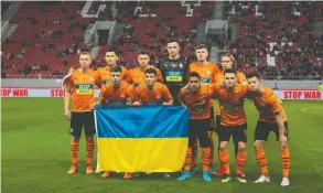  ?? YORGOS KARAHALIS / THE ASSOCIATED PRESS FILES ?? Players from Shakhtar Donetsk hold a Ukrainian flag ahead of a recent friendly charity
soccer match against Olympiakos at Karaiskaki stadium in Piraeus, near Athens.