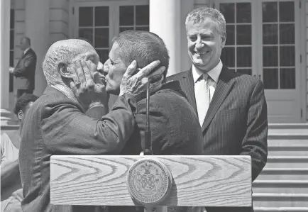  ?? TIMOTHY A. CLARY/AFP VIA GETTY IMAGES ?? Terrence McNally, left, and Thomas Kirdahy renew their vows as New York City Mayor Bill de Blasio officiates on the steps of city hall in 2015.