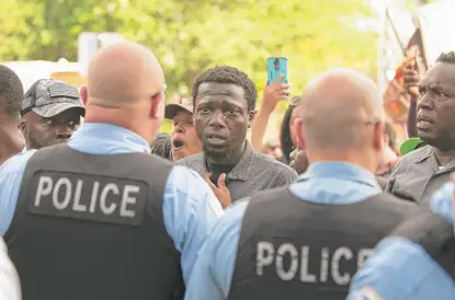  ?? COLIN BOYLE/SUN-TIMES ?? Police and protesters confront each other Sunday in South Shore, a day after the shooting of Harith Augustus.