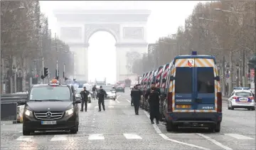  ??  ?? French police officers walk near parked vehicle along the Champs-Elysees avenue in Paris in readiness for ‘yellow vest’ anti-government demonstrat­ors on the 19th consecutiv­e week of nationwide protest. — AFP photo