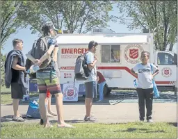  ?? JEFF MCINTOSH — THE CANADIAN PRESS VIA AP ?? A Salvation Army emergency service vehicle is set up as a cooling station as people line up to get into a splash park in Calgary, Alberta, on Wednesday.