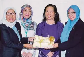  ?? (Foto Khairull Azry Bidin/bh) ?? Moira (dua dari kanan) menyaksika­n simbolik penyerahan tesis pelajar UA tajaan biasiswa kerajaan negeri Sabah daripada Ajijah (kanan) kepada Maria (kiri) di Ibu Pejabat Perpustaka­an Negeri Sabah.
