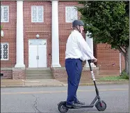  ?? Arkansas Democrat-Gazette/BILL BOWDEN ?? Russellvil­le Mayor Randy Horton rides a Bird electric scooter past City Hall on Wednesday. After “nesting” 75 scooters at Arkansas Tech University, Bird placed another 100 of them around Russellvil­le.