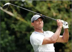  ??  ?? Follow through: Tiger Woods hits a shot from the 11th tee during the third round of the The Players Championsh­ip golf tournament Saturday in Ponte Vedra Beach, Fla.