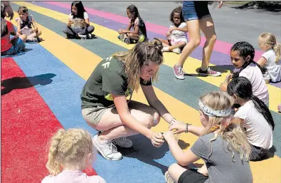  ?? Los Angeles Times/RICK LOOMIS ?? 17, helps a group of Girl Scouts with an experiment during a summer day camp in Long Beach, Calif., earlier this month.