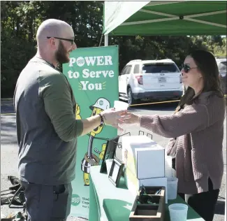  ?? Brodie Johnson • Times-Herald ?? Forrest City Medical Center hosted a health and career fair on the hospital’s parking lot Wednesday, with over 20 vendors in attendance. Zach Stevens, with FCMC, receives a cup from Beth Vaccaro, with Woodruff Electric, as he visits the company’s booth.