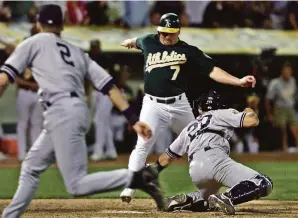  ?? Eric Risberg / Associated Press 2001 ?? The A’s Jeremy Giambi (7) is tagged out at home by Yankees catcher Jorge Posada in Game 3 of the 2001 ALDS after a memorable toss from shortstop Derek Jeter (2).