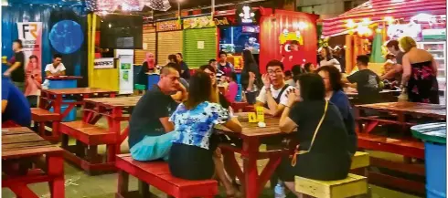  ??  ?? Trendy stalls: Patrons eating and chatting at the ASquare Container night market, a favourite spot for many in Kota Kinabalu.