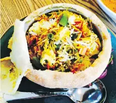  ??  ?? Biryani, cooked in the tandoor oven, is served in a pot with baked dough stretched tightly over it.