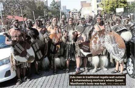  ?? /VELI NHLAPO ?? Zulu men in traditiona­l regalia wait outside a Johannesbu­rg mortuary where Queen Mantfombi’s body was kept.