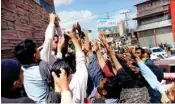  ?? PTI ?? Daily wage workers, jobless due to the Coronaviru­s outbreak, jostle to receive money being distribute­d by an individual, in Quetta, Pakistan, Tuesday