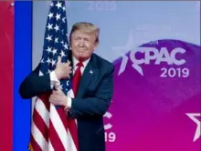  ?? Jose Luis Magana/Associated Press ?? President Donald Trump hugs the American flag as he arrives to speak at Conservati­ve Political Action Conference on Saturday in Oxon Hill, Md.