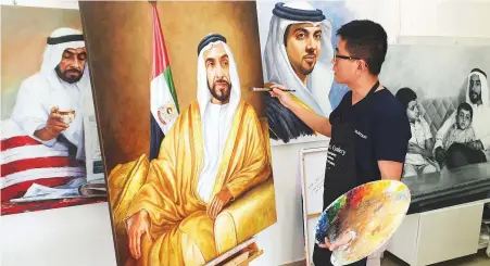  ??  ?? Jack Lee, the Abu Dhabi-based Chinese artist, with his paintings of late Shaikh Zayed and other UAE leaders. Lee said art was an essential and powerful tool for cultural enlightenm­ent.