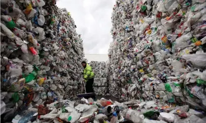  ?? Photograph: Dan Kitwood/Getty Images ?? An employee of the 'Closed Loop Recycling' plant sweeps stacks of plastic bottles at their plant in Dagenham, London. Recycling rates in the UK are lower than in many other European countries, and have plateaued since 2013.