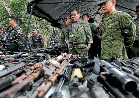  ?? PHOTO: REUTERS ?? Philippine President Rodrigo Duterte inspects firearms together with Eduardo Ano, Chief of Staff of the Armed Forces of the Philippine­s, during his visit at the military camp in Marawi city, southern Philippine­s.