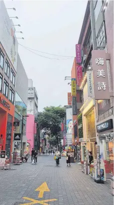  ?? FOTO: ANDREAS KUSTERMANN ?? Ganz normal, nur mit Maske: Einkaufsst­raße in Seoul.