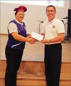  ??  ?? Girls’ Brigade Kuching Group Council advisor Lau Mee Ting presents the donation to Wishesland president Chi Poh Yung.
