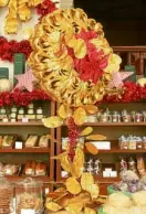  ??  ?? A gold-leaf solar circlet with red poinsettia­s adorns the tables.