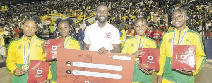  ?? ?? While handing over a symbolic cheque of $150,000 in tuition support to the team, Digicel Chief Marketing Officer Tari Lovell (centre) shares the lens with the St Jago High Class Three Girls’ 4x100m relay team (from left) Shavone Williams, Martina Parkes, Trecia-ann Grant, and Adora Campbell.