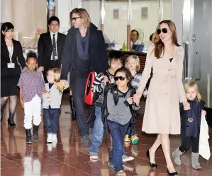  ?? — Gambar AFP ?? GAMBAR fail bertarikh 8 November 2011 ini menunjukka­n Pitt (lima kiri) bersama Angellina Jolie dan enam anak mereka semasa tiba di lapangan terbang Haneda, Tokyo.