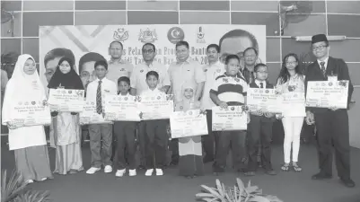  ??  ?? KHALED bergambar bersama murid-murid sekolah yang menerima bantuan subsidi tambang bas sekolah pada Majlis Program Bantuan Subsidi Tambang Bas Sekolah di Dewan Taman Cendana kelmarin. - Gambar BERNAMA