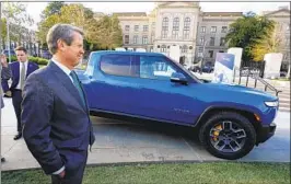  ?? JOHN BAZEMORE AP ?? Georgia Gov. Brian Kemp stands next to a Rivian electric truck. The EV trucks will be built in a plant east of Atlanta.