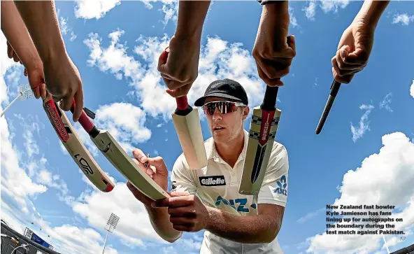  ?? AP ?? New Zealand fast bowler Kyle Jamieson has fans lining up for autographs on the boundary during the test match against Pakistan.