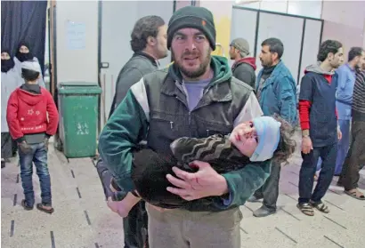  ?? AFP ?? A Syrian man carries a wounded infant at a makeshift hospital in the rebel-held town of Douma, in Eastern Ghouta, on Tuesday. —