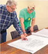  ??  ?? Danny Frey, left, and Mark Ronchetti go over blueprints for the home being built in Angel Fire.