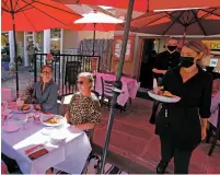  ?? LUIS SÁNCHEZ SATURNO/ NEW MEXICAN FILE PHOTO ?? Cecilia Burton delivers food to Santa Fe visitors at La Boca in 2020. La Boca is in one part of a pair of downtown Santa Fe buildings expected to be bought by a real estate owner.